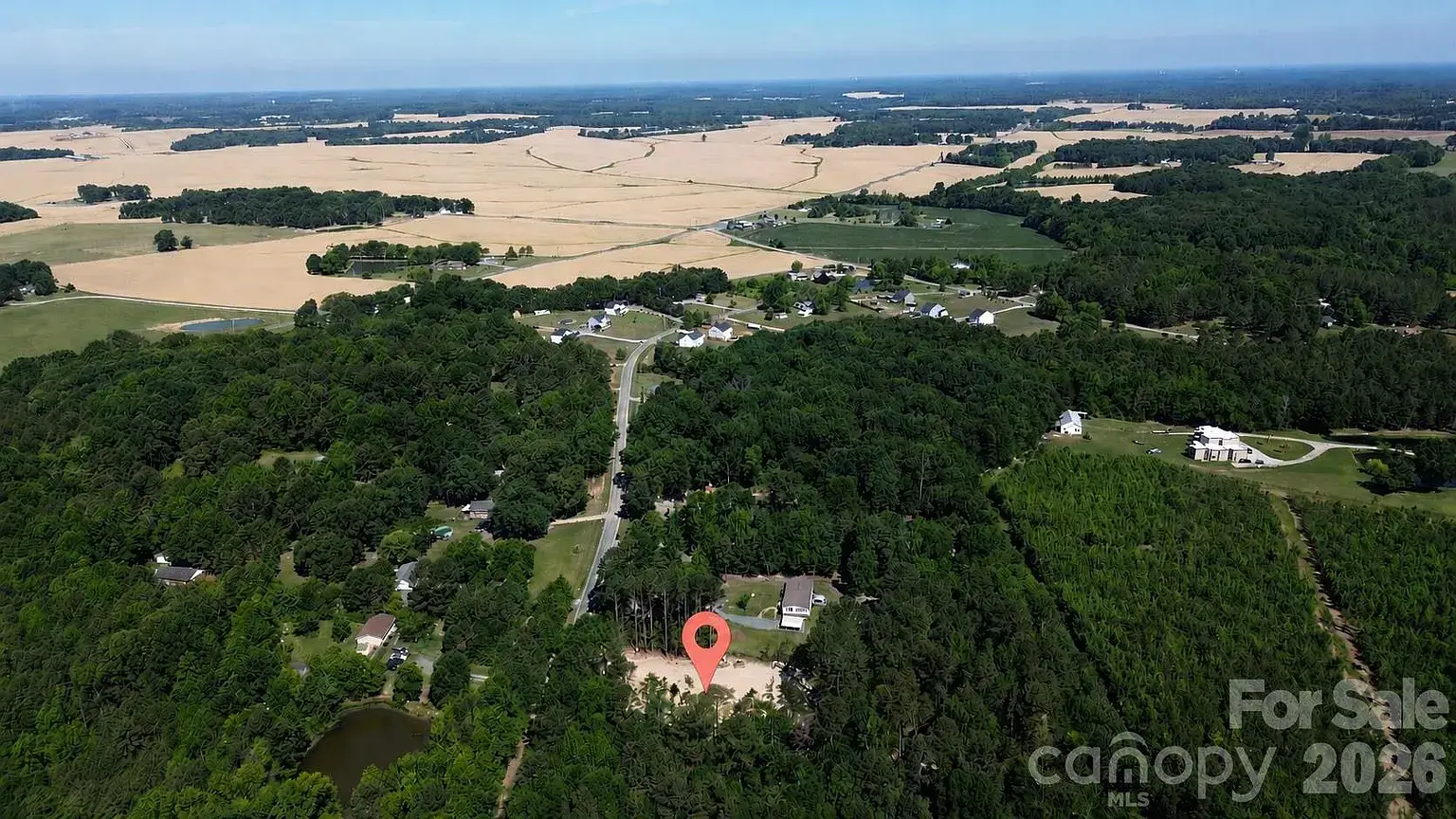 Aerial view of the Monroe, North Carolina homesite location highlighted within a wooded rural landscape surrounded by farmland and custom homes.