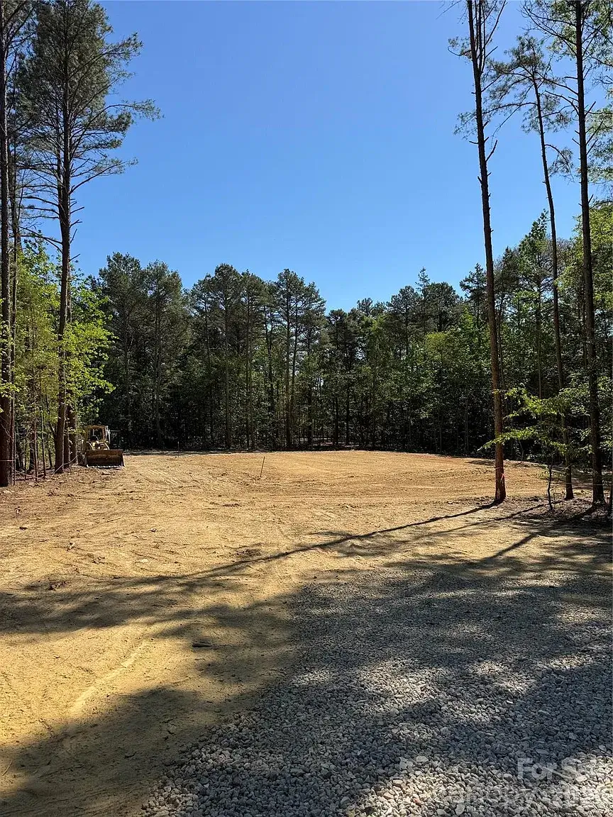 Cleared and graded homesite on a wooded 2-acre lot in Monroe, North Carolina, prepared for custom home construction.